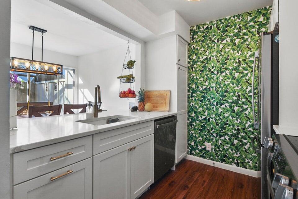 6335 Riverwalk Lane, Unit 3 Jupiter, FL 33458 - Photo 8 of 20 a kitchen with sink and wooden floor