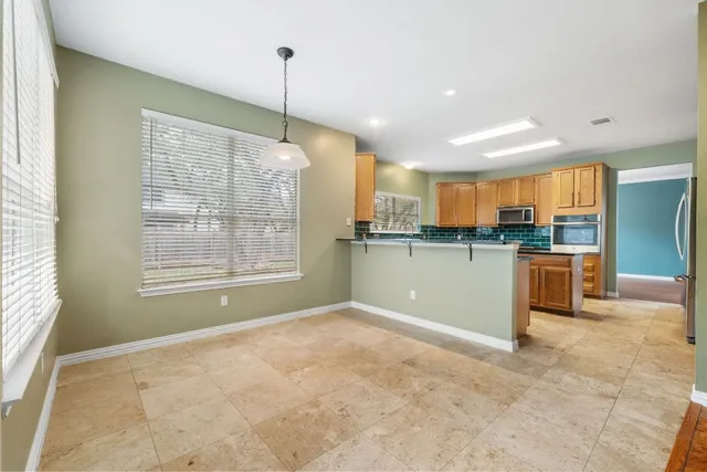 a kitchen with stainless steel appliances granite countertop a refrigerator a sink and a stove