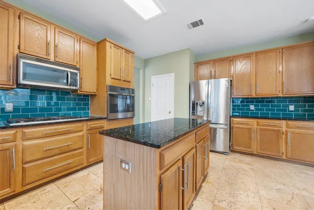 a kitchen with stainless steel appliances granite countertop a refrigerator and cabinets