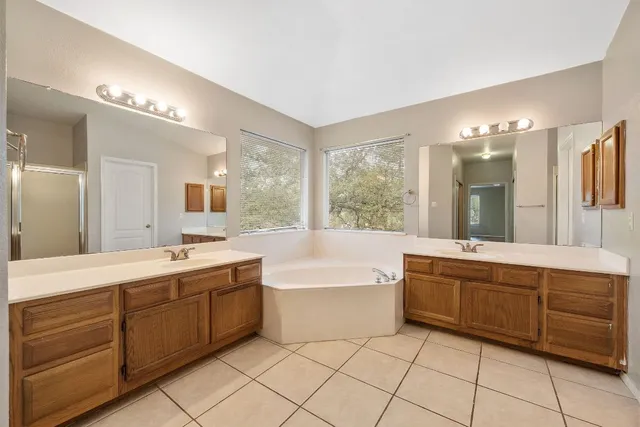 a spacious bathroom with a large tub shower and sink