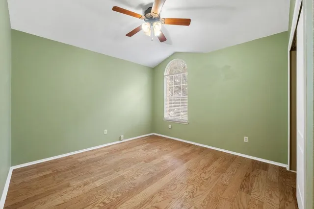 an empty room with a window and a fan