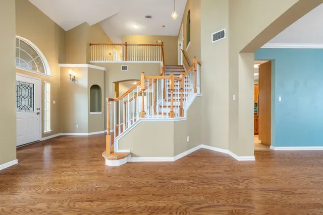 a view of a hallway with entryway and wooden floor