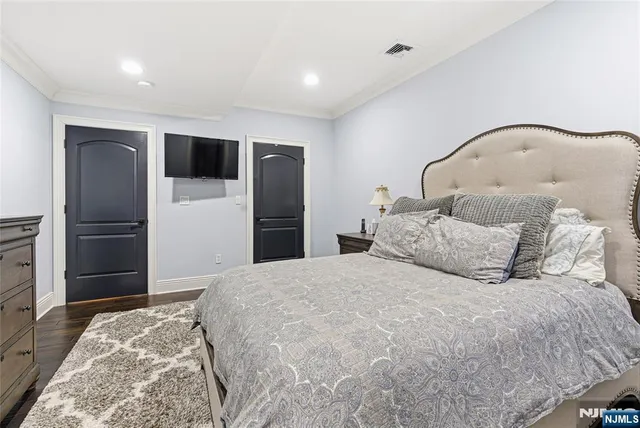 a bedroom with a large bed and a refrigerator