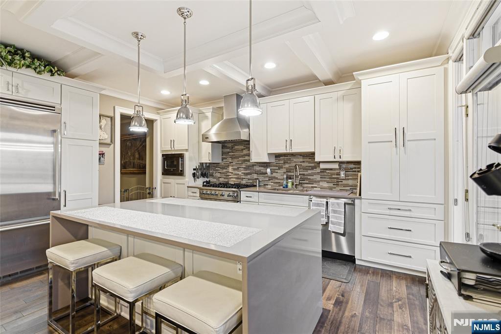 119 Hudson Cove Edgewater, NJ 07020 - Photo 5 of 44 a large white kitchen with a refrigerator a stove a sink and a dining table with wooden floor