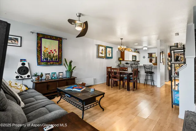 a living room with lots of furniture and paintings on the wall
