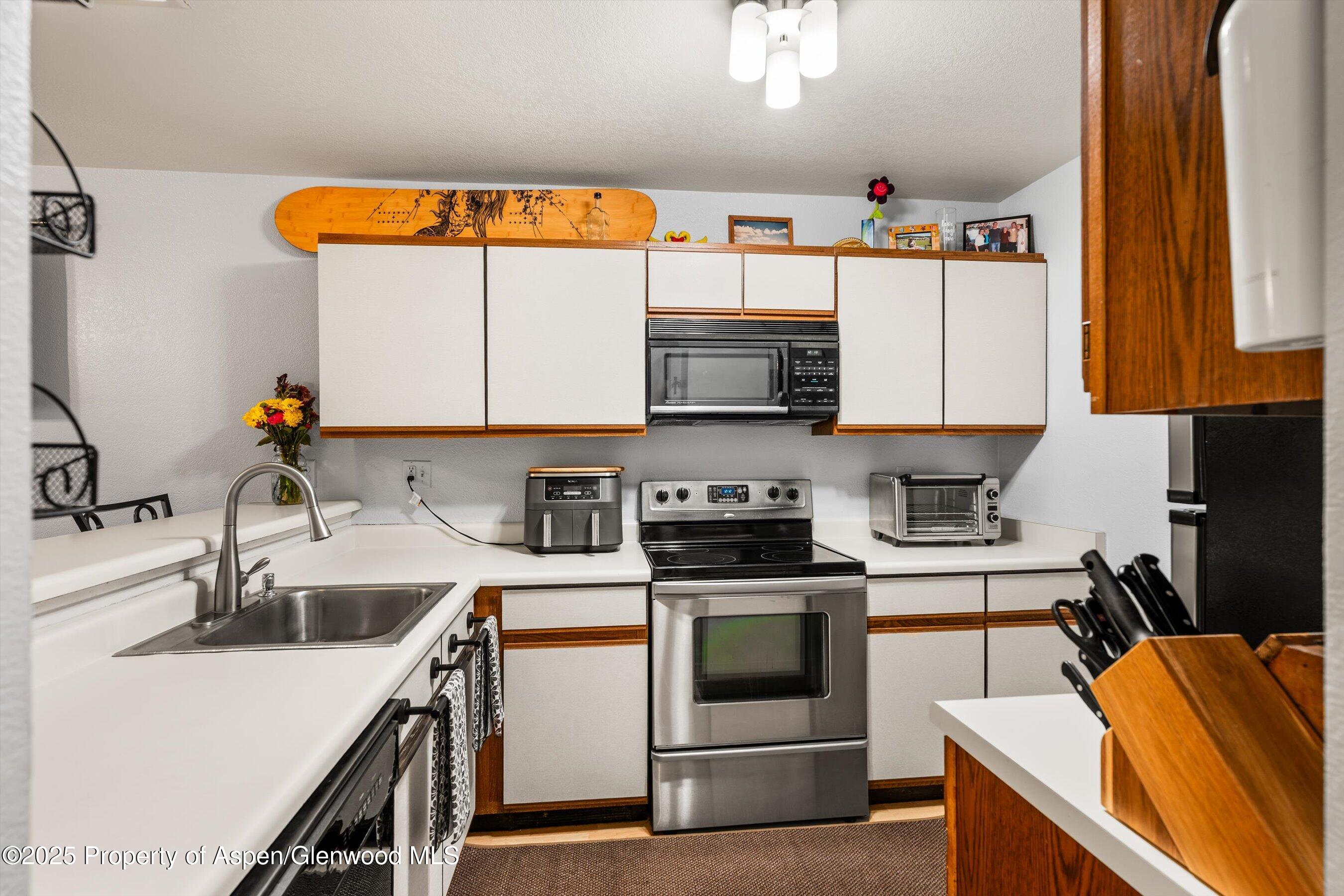 323 Park Avenue, Unit G2 Basalt, CO 81621 - Photo 4 of 17 a kitchen with stainless steel appliances a stove a sink and a microwave