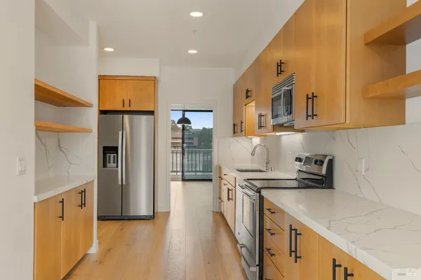 a view of a living room hardwood floor and a large window