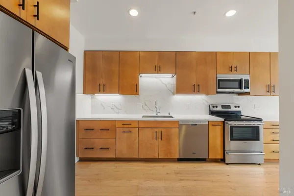 a kitchen with stainless steel appliances granite countertop a refrigerator and a stove