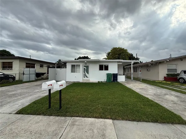 a front view of a house with a yard and trees
