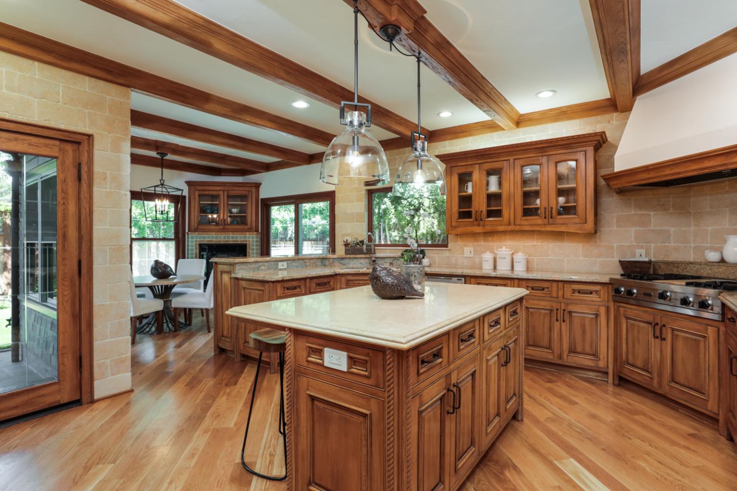 255 Lyell Street Los Altos, CA 94022 - Photo 15 of 50 a kitchen with stainless steel appliances granite countertop a stove a sink dishwasher and a dining table with wooden floor