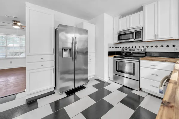 a kitchen with granite countertop stainless steel appliances a stove a microwave and cabinets