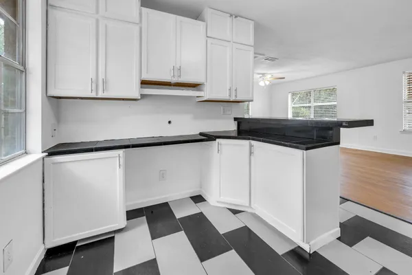 a kitchen with granite countertop white cabinets and sink