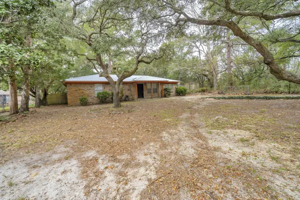 a front view of a house with yard and tree