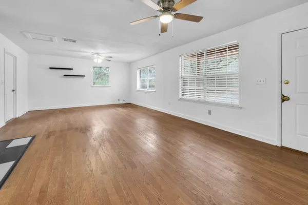 wooden floor in an empty room with a window