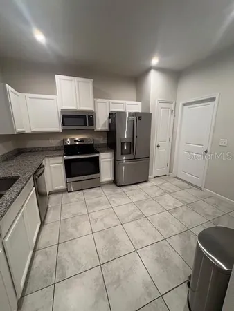 a kitchen with stainless steel appliances a refrigerator sink and cabinets