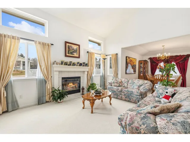 a living room with furniture a fireplace and a large window