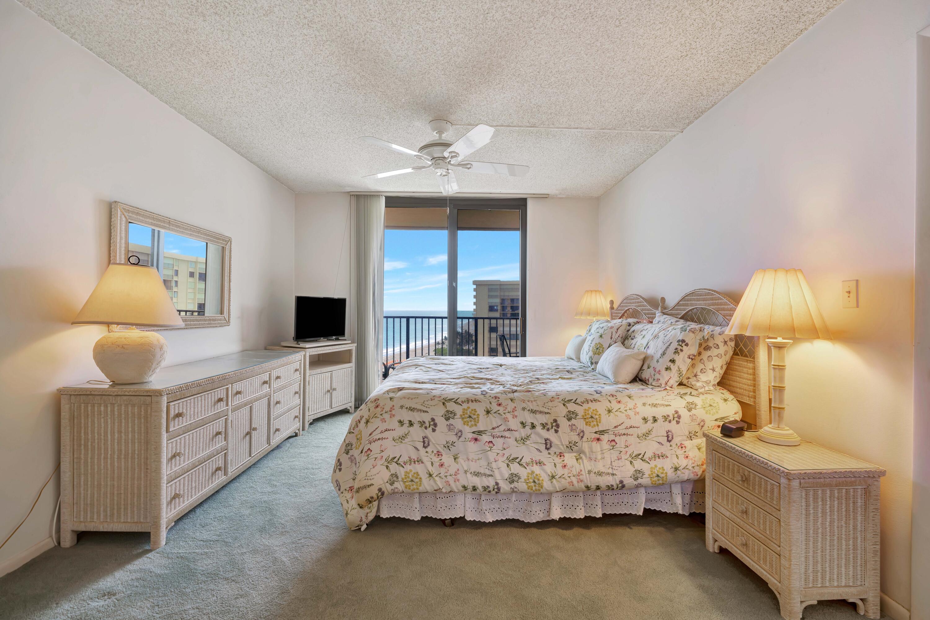200 Ocean Trail Way, Unit 1009 Jupiter, FL 33477 - Photo 15 of 36 a bedroom with a bed and a chandelier fan