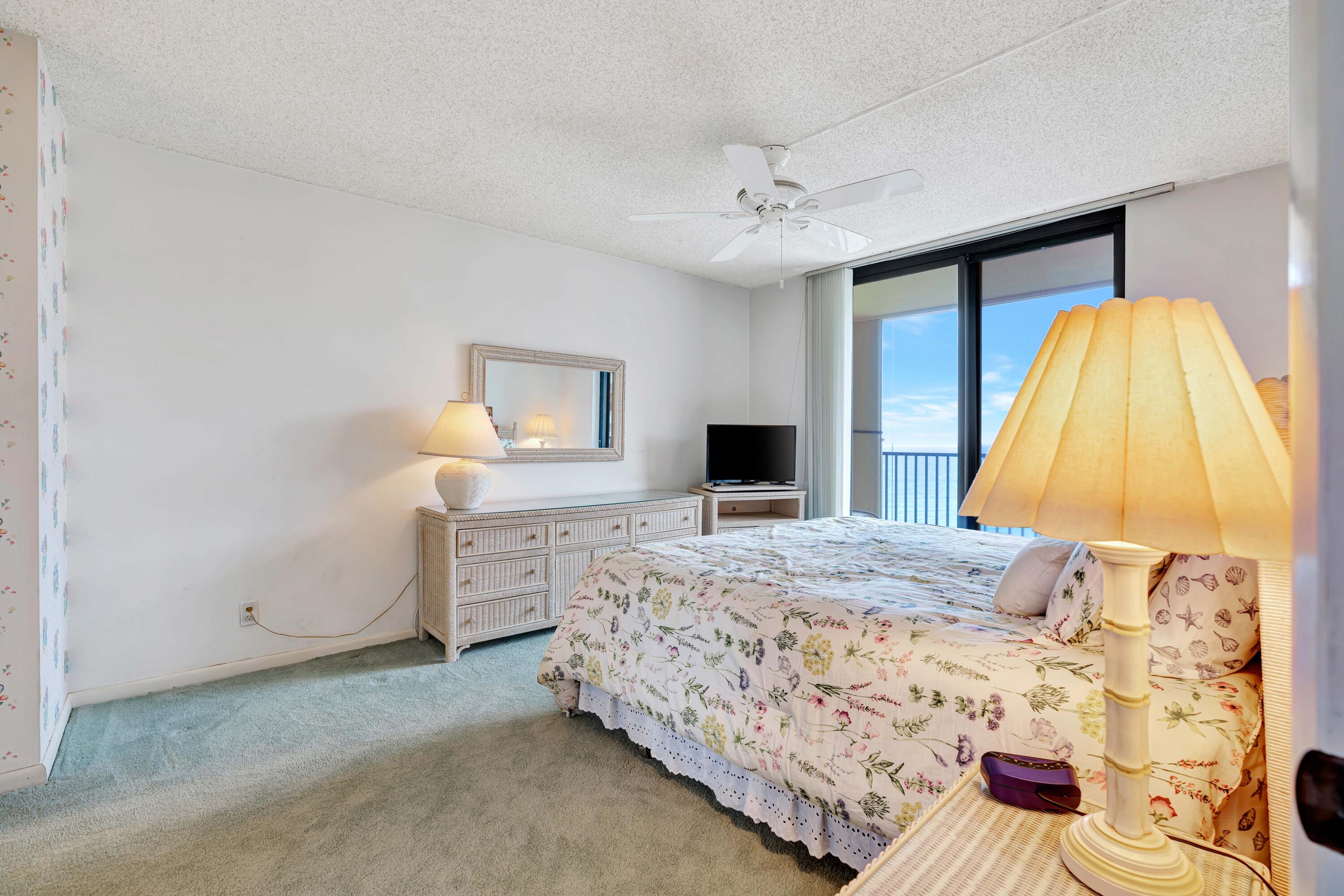 200 Ocean Trail Way, Unit 1009 Jupiter, FL 33477 - Photo 16 of 36 a bedroom with a bed and a flat screen tv