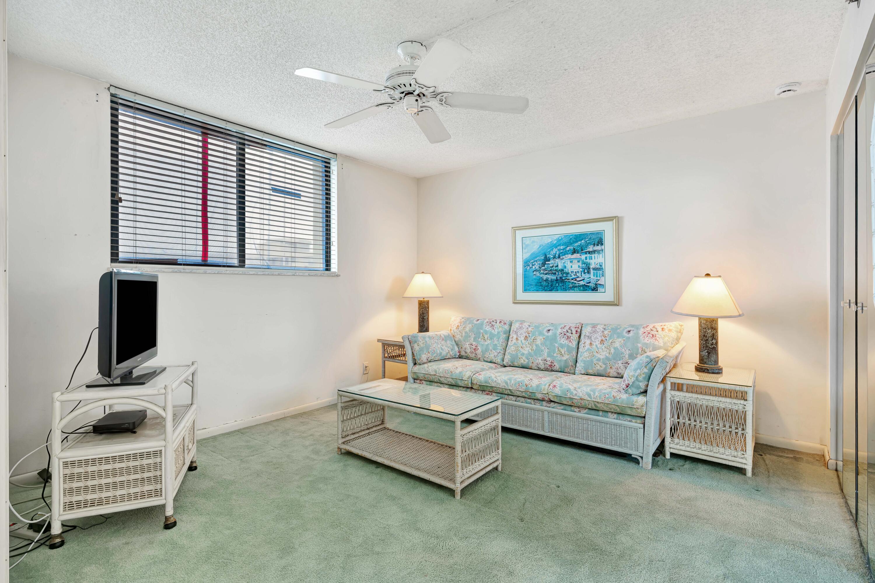 200 Ocean Trail Way, Unit 1009 Jupiter, FL 33477 - Photo 17 of 36 a living room with furniture a lamp and a flat screen tv