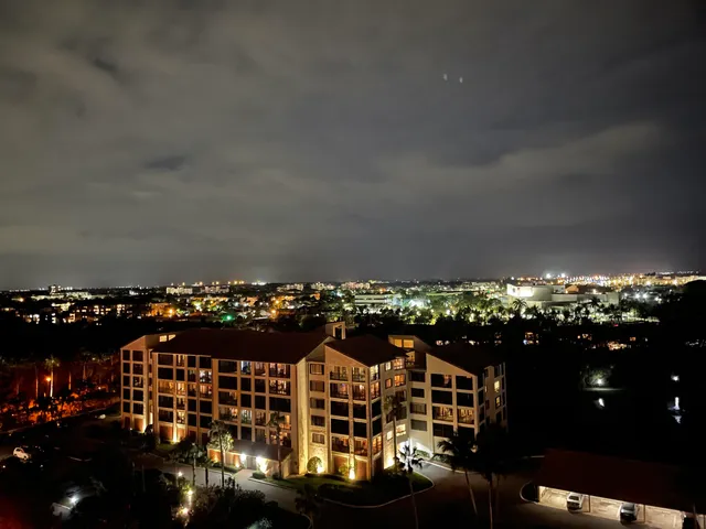 an aerial view of ocean and residential houses with outdoor space