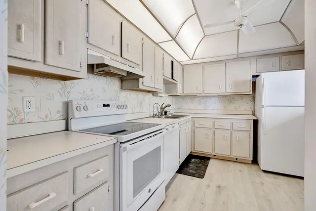 a kitchen with stainless steel appliances granite countertop a sink and a refrigerator