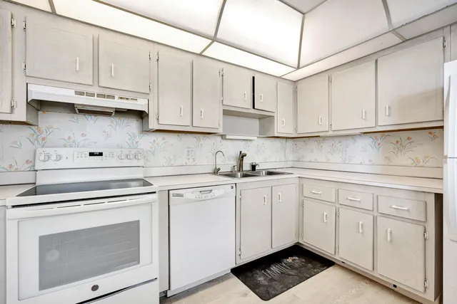 a kitchen with a sink a refrigerator and cabinets