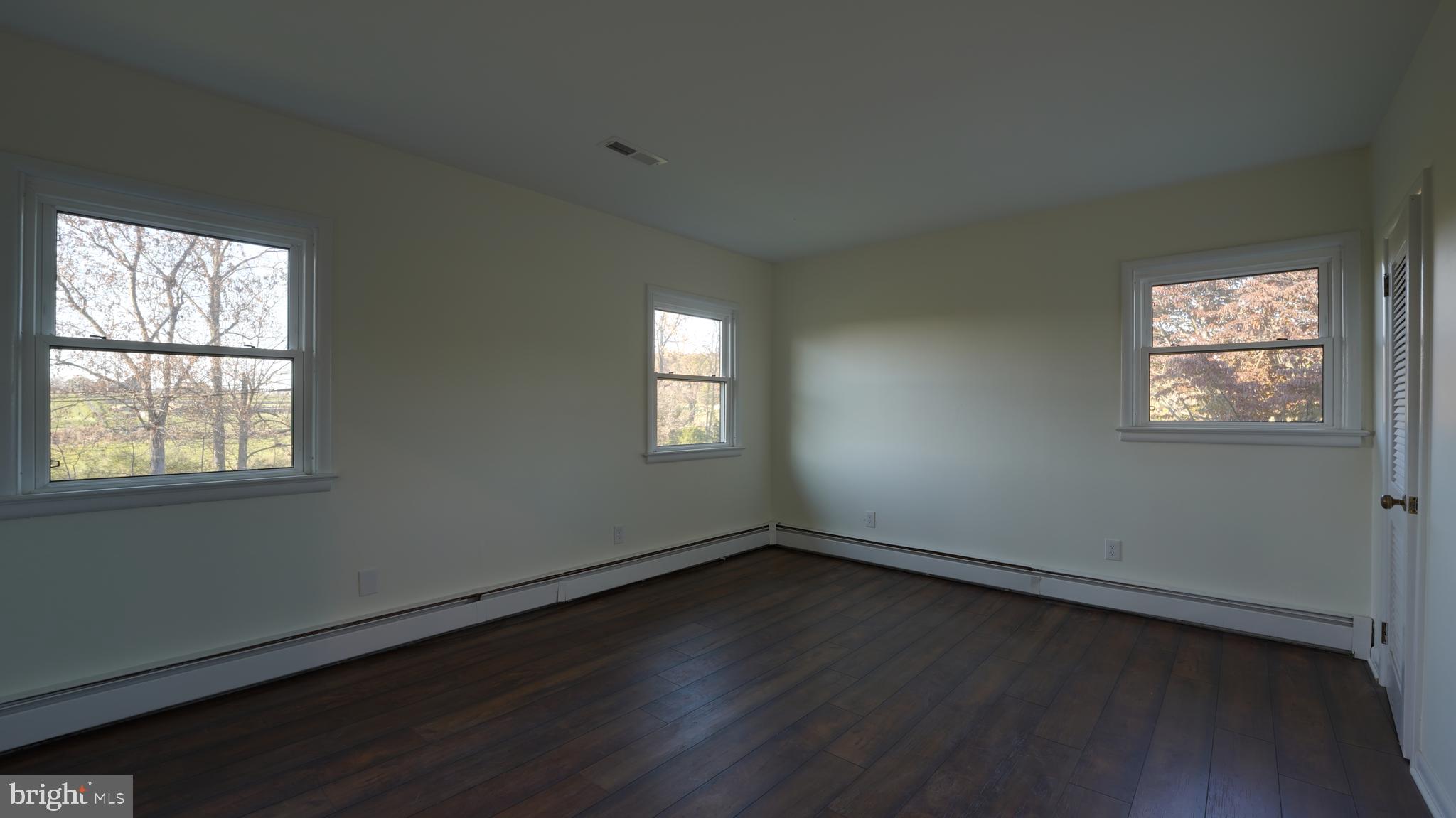 53 Iron Bridge Road Pipersville, PA 18947 - Photo 21 of 28 an empty room with wooden floor and windows