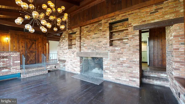 an empty room with wooden floor and a fireplace
