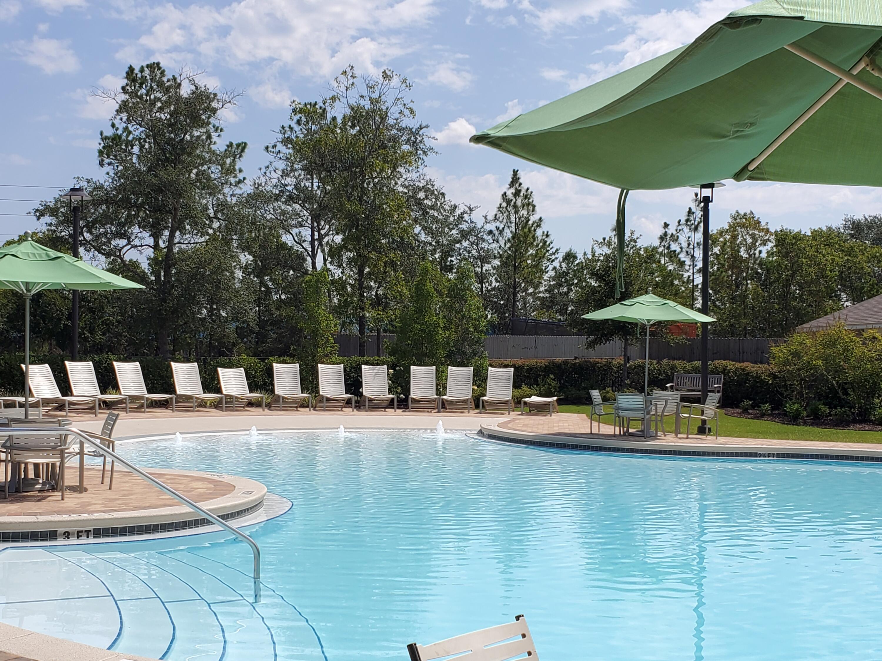 931 Merganser Way Crestview, FL 32539 - Photo 2 of 37 a view of a lake with a table and chairs under an umbrella