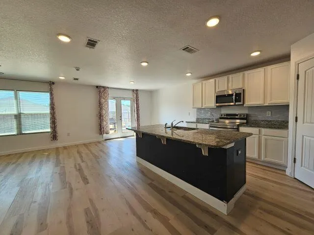 a bathroom with a granite countertop sink a toilet a mirror and shower