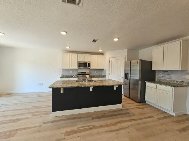 931 Merganser Way Crestview, FL 32539 - Photo 8 of 37 a large kitchen with stainless steel appliances granite countertop a stove and a refrigerator