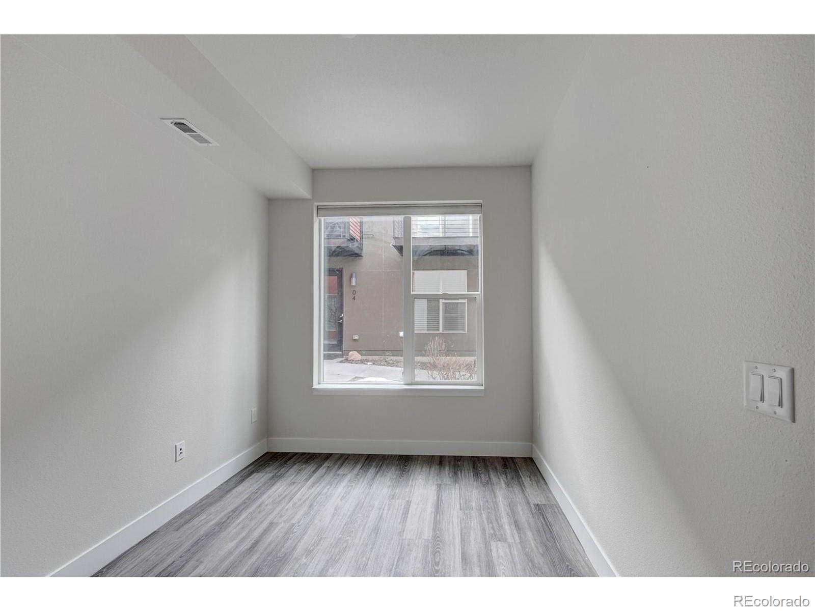 3080 Wilson Court, Unit 3 Denver, CO 80205 - Photo 12 of 28 a view of an empty room with wooden floor and a window
