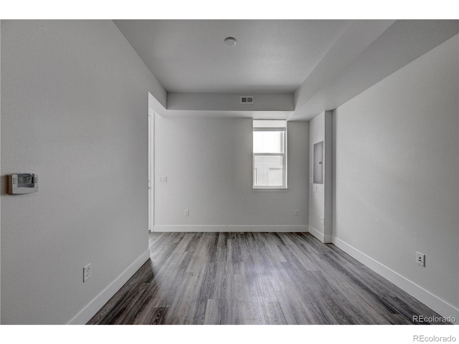 3080 Wilson Court, Unit 3 Denver, CO 80205 - Photo 9 of 28 a view of an empty room with wooden floor and a window