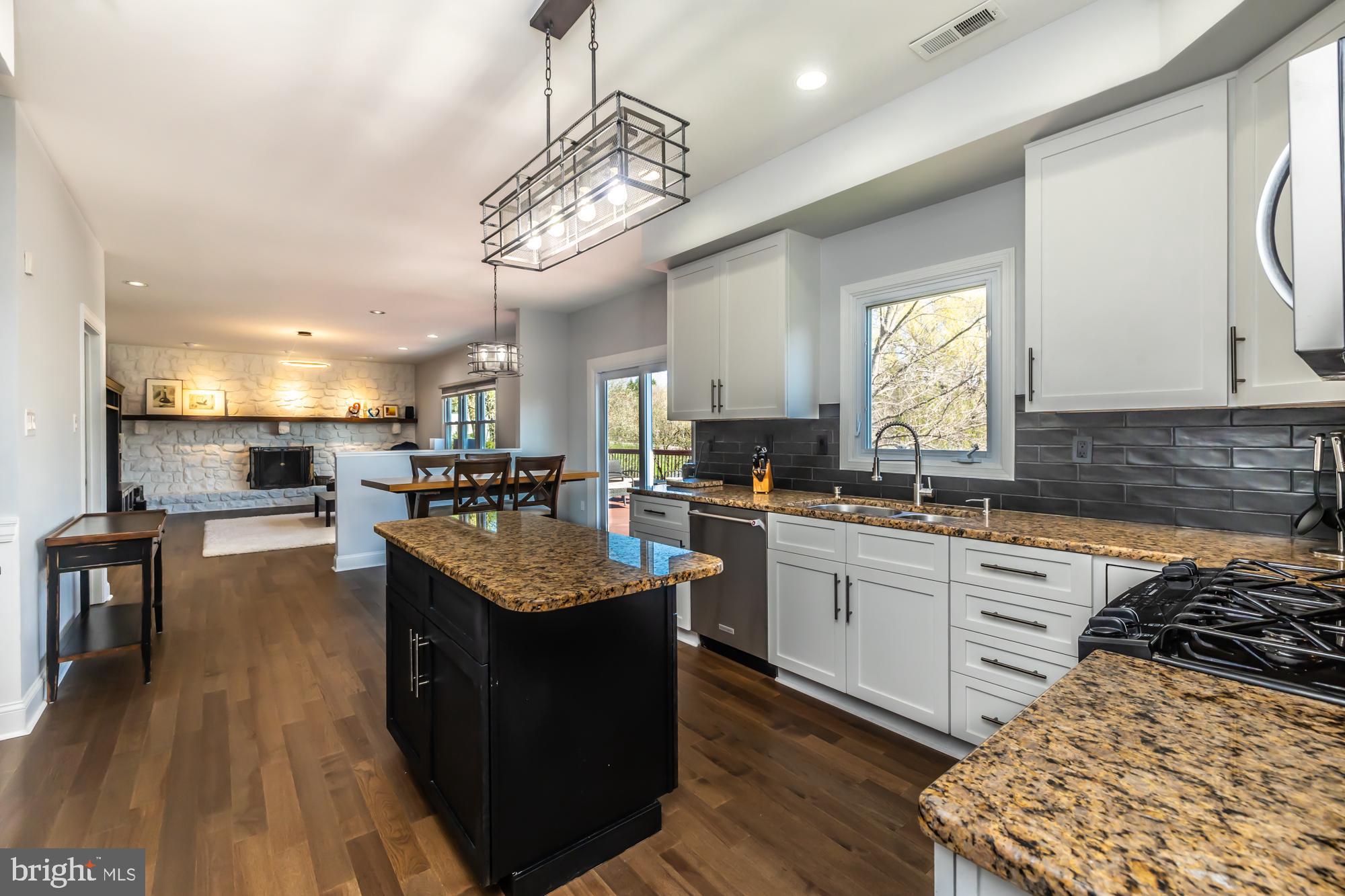 1537 Foxbury Road Ambler, PA 19002 - Photo 15 of 52 a kitchen with stainless steel appliances granite countertop a stove a sink dishwasher and a dining table with wooden floor
