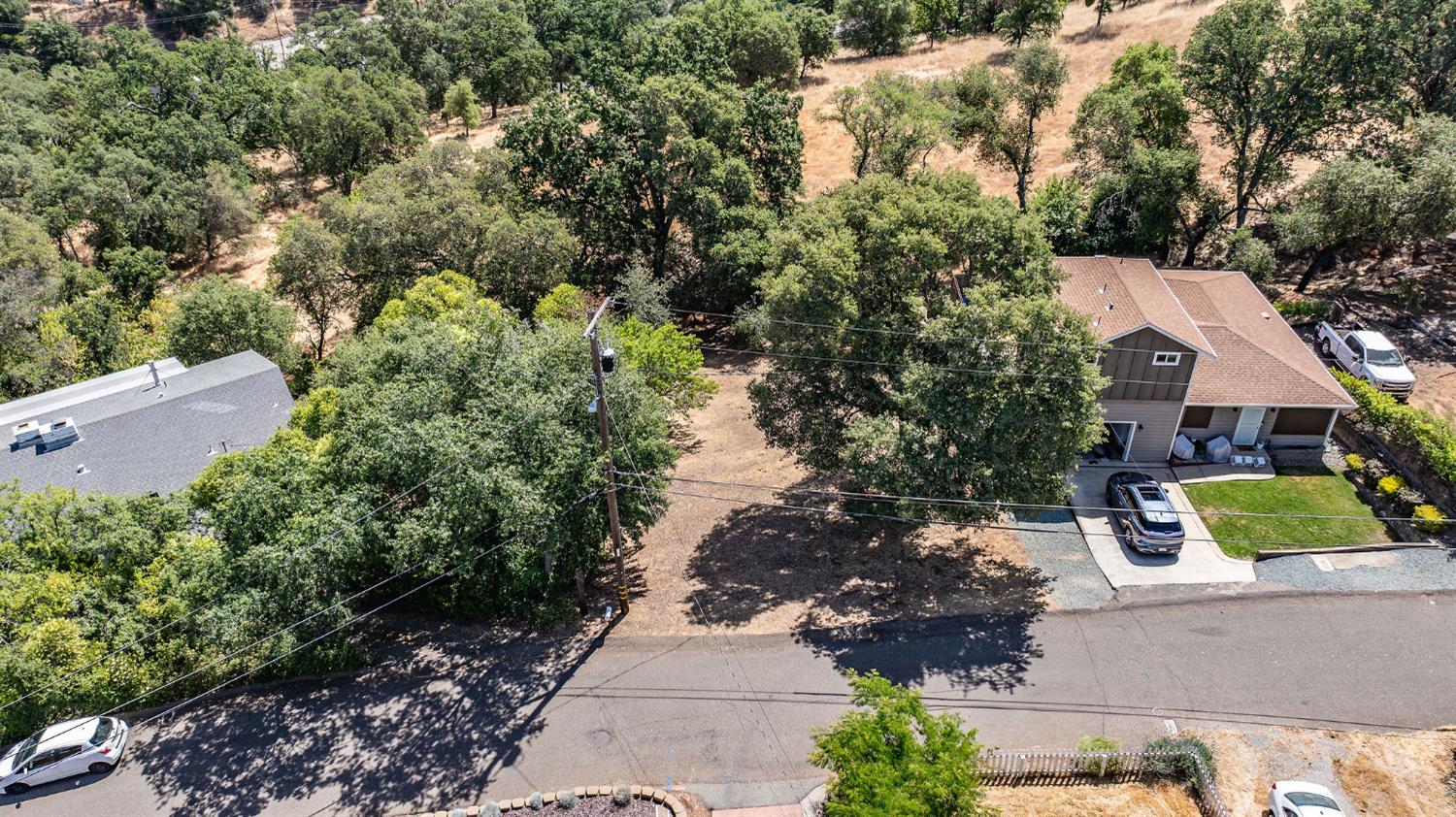 an aerial view of a house with yard and mountain view in back