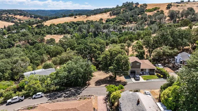 an aerial view of house with yard and mountain view in back