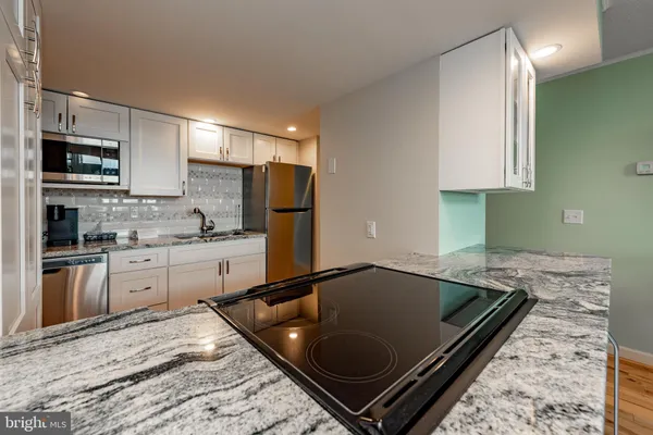 a kitchen with a refrigerator and a stove top oven