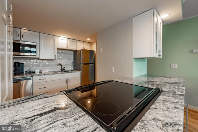 a kitchen with a refrigerator and a stove top oven
