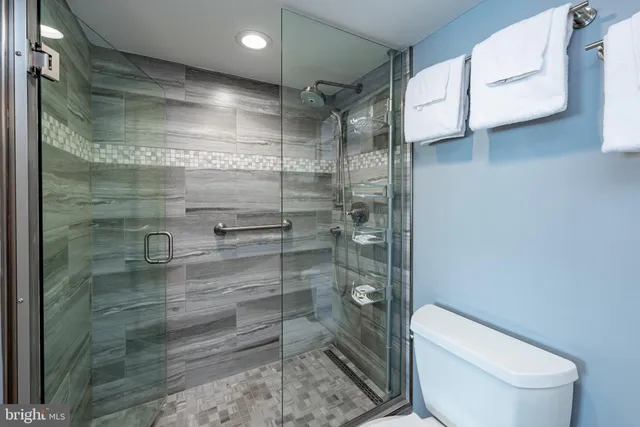 a bathroom with a granite countertop sink and a toilet