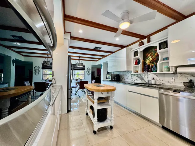 a kitchen with stainless steel appliances kitchen island granite countertop a refrigerator and microwave