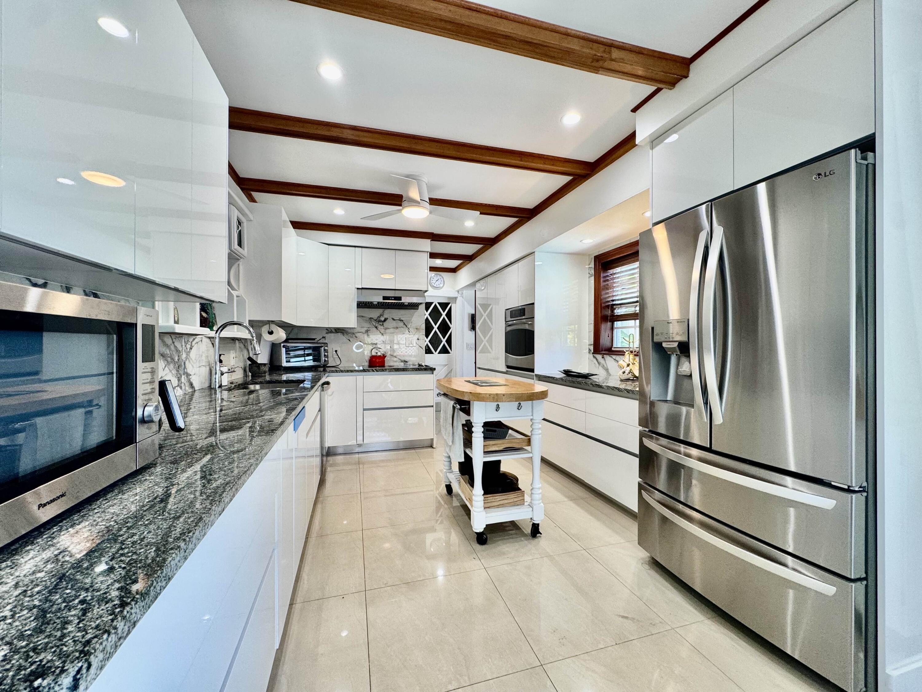 2802 Southwest 4th Street Boynton Beach, FL 33435 - Photo 12 of 42 a kitchen with stainless steel appliances kitchen island granite countertop a refrigerator and microwave