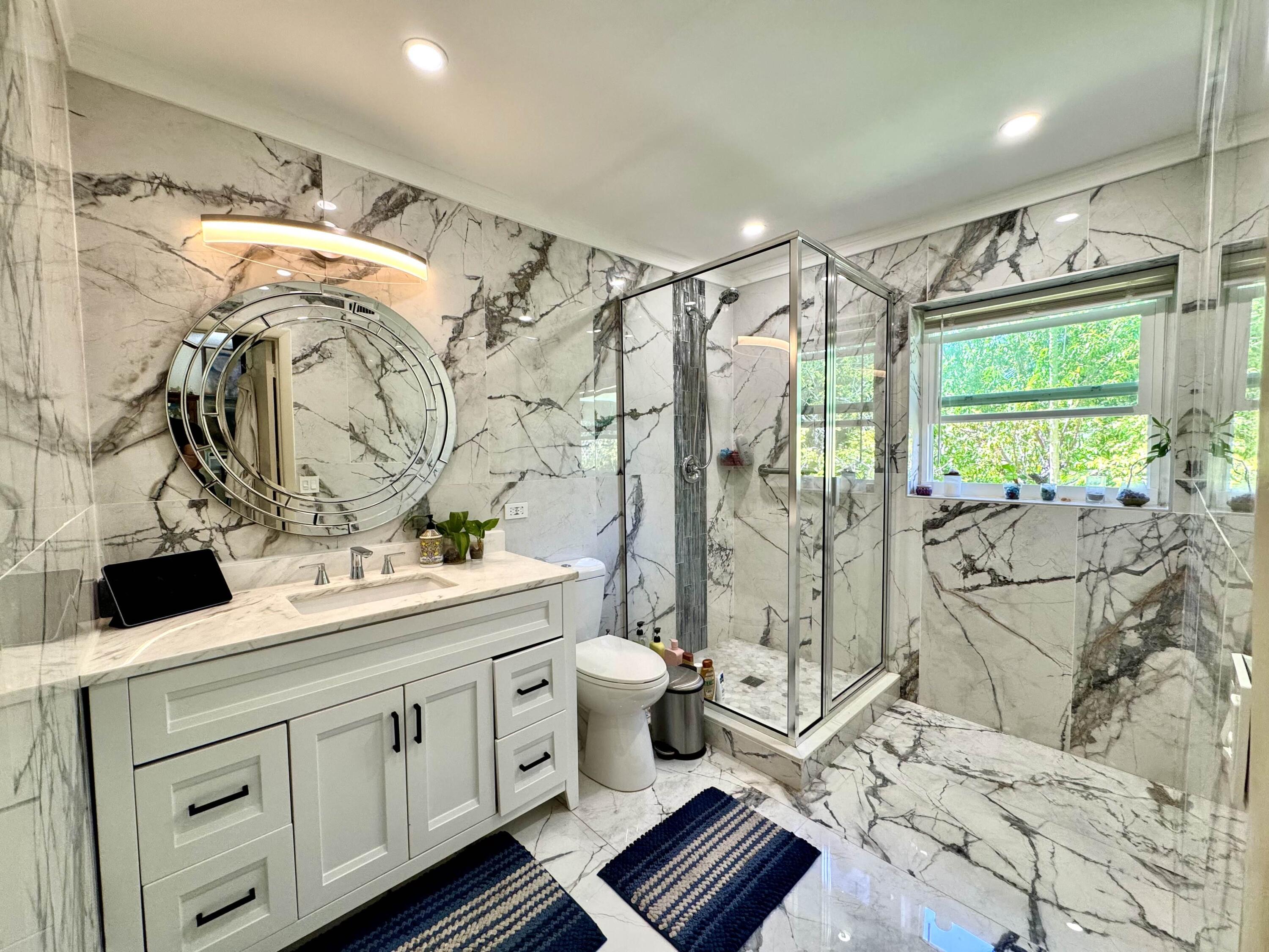 2802 Southwest 4th Street Boynton Beach, FL 33435 - Photo 22 of 42 a spacious bathroom with a double vanity sink toilet mirror and shower