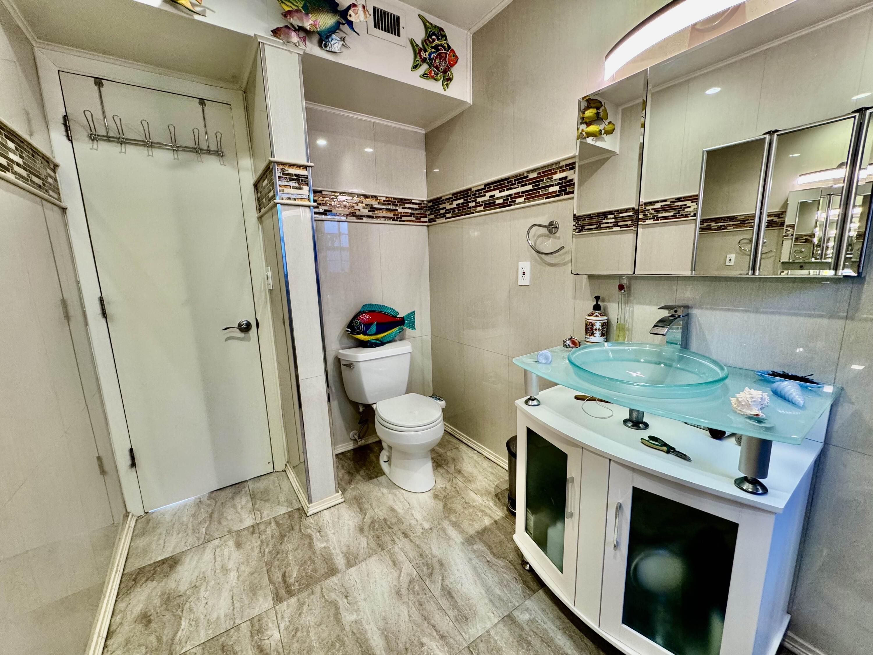 2802 Southwest 4th Street Boynton Beach, FL 33435 - Photo 31 of 42 a bathroom with a sink a toilet and shower