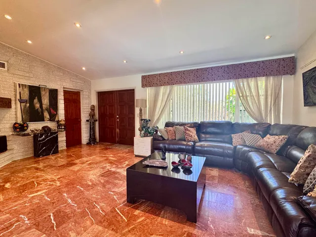 a living room with furniture and large windows