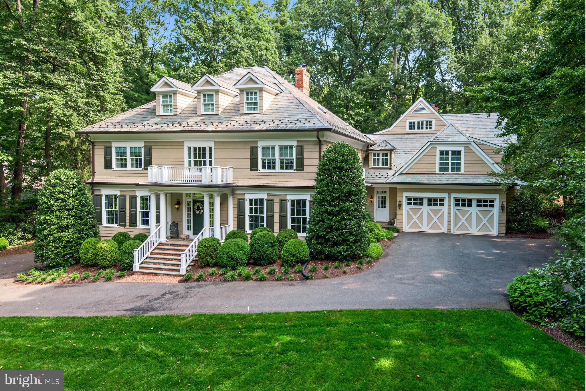 a front view of a house with a yard and potted plants