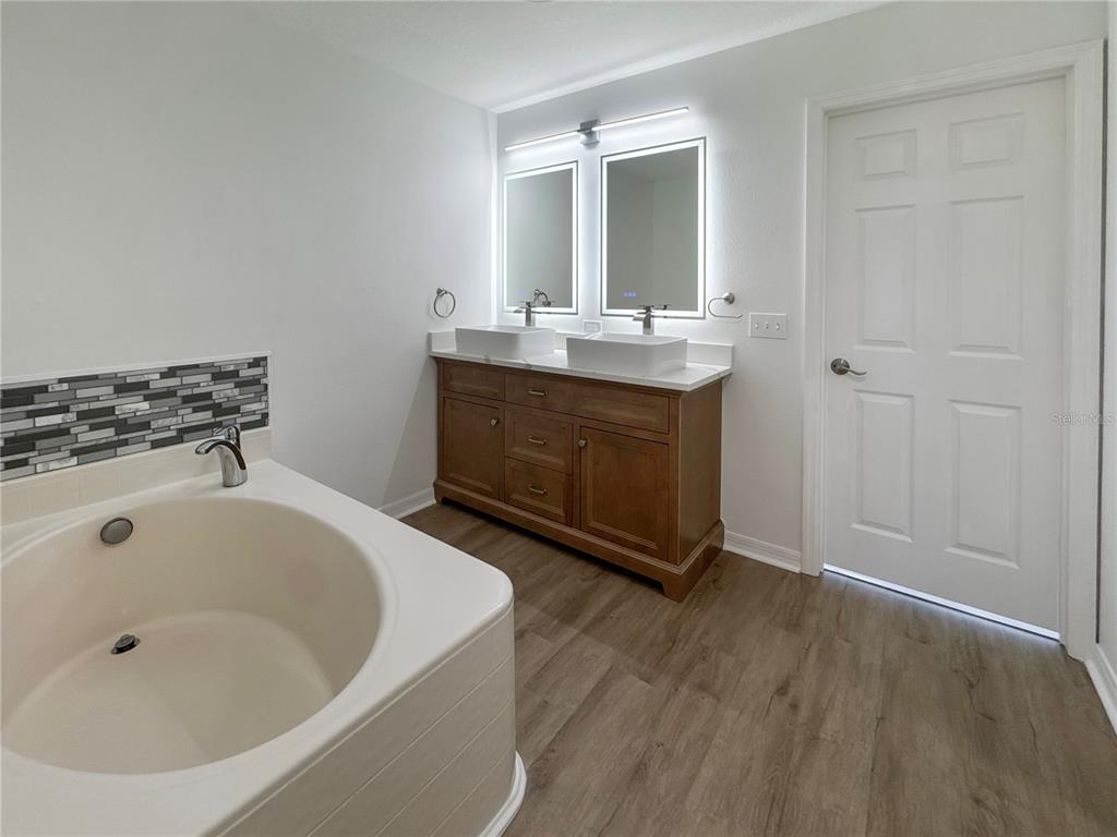 2109 Aitkin Loop Leesburg, FL 34748 - Photo 17 of 33 a bathroom with a tub sink and mirror