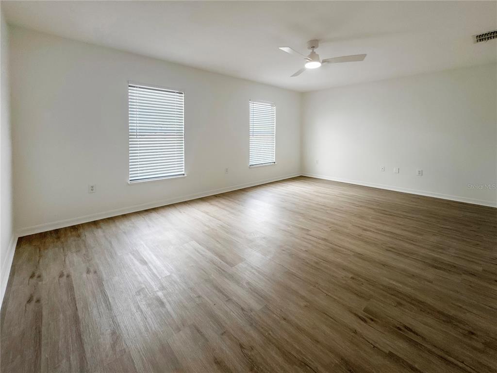 2109 Aitkin Loop Leesburg, FL 34748 - Photo 20 of 33 an empty room with wooden floor and windows
