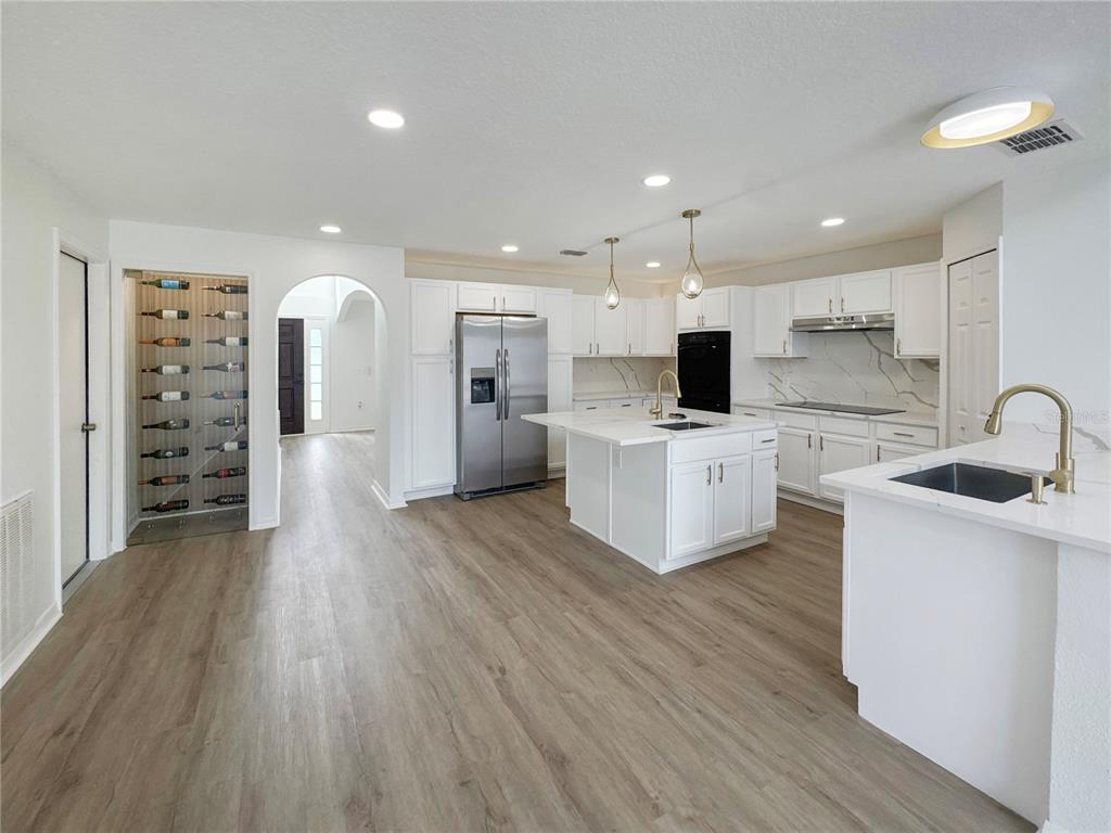 2109 Aitkin Loop Leesburg, FL 34748 - Photo 2 of 33 a large kitchen with stainless steel appliances a large counter top a sink and a refrigerator