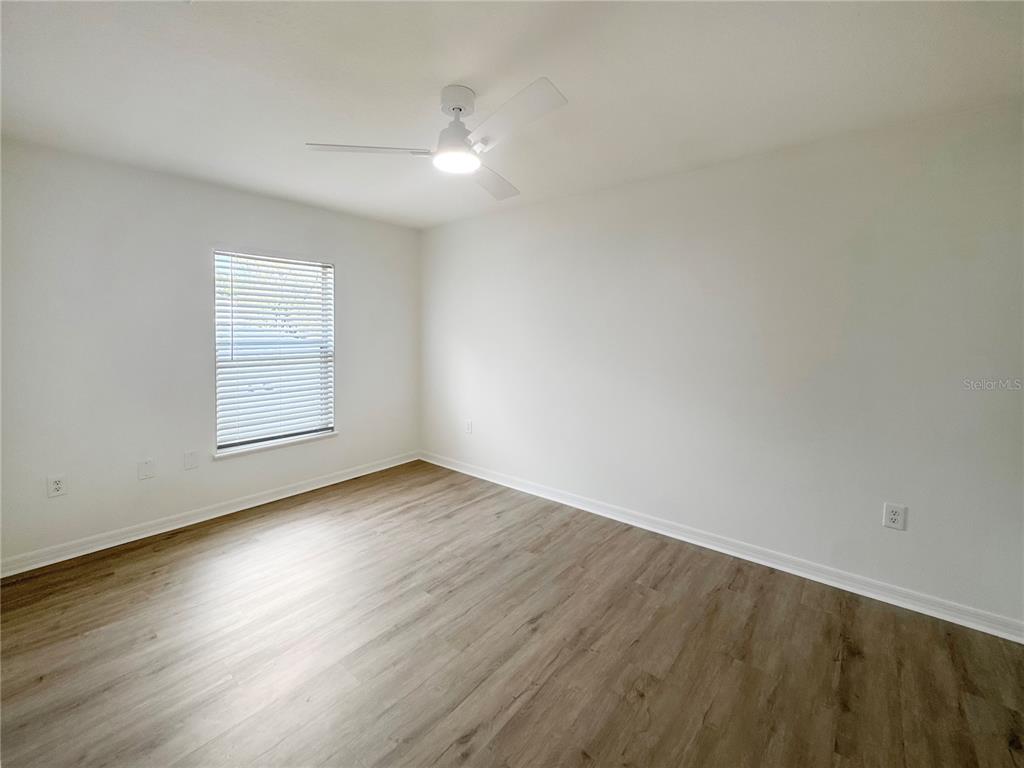 2109 Aitkin Loop Leesburg, FL 34748 - Photo 21 of 33 an empty room with wooden floor and windows