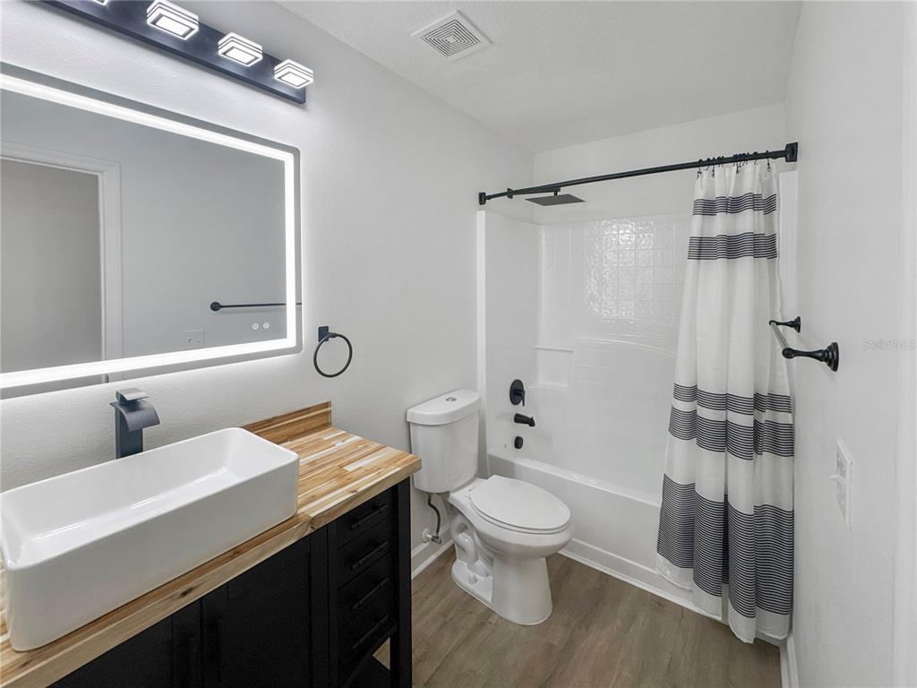 2109 Aitkin Loop Leesburg, FL 34748 - Photo 22 of 33 a bathroom with a sink a toilet and shower